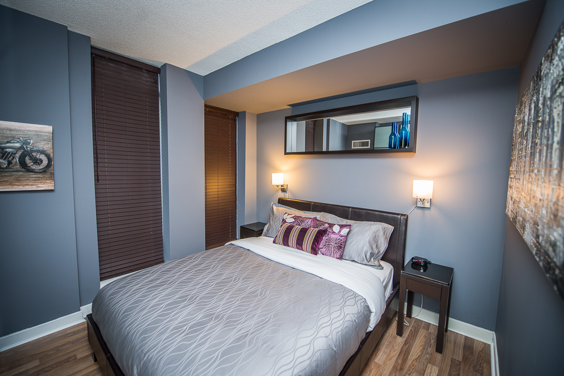 King and Yonge executive rentals toronto bedroom with purple pillows on bed