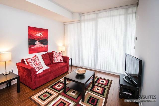 8 Telegram Mews serviced apartments toronto red couch and rug