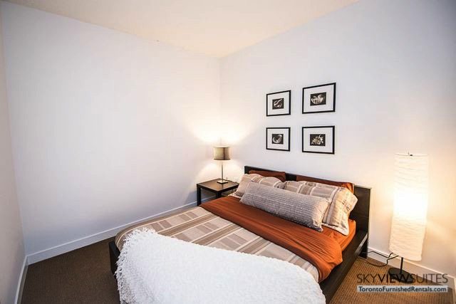 8 Telegram Mews serviced apartments toronto bed with brown sheets and art