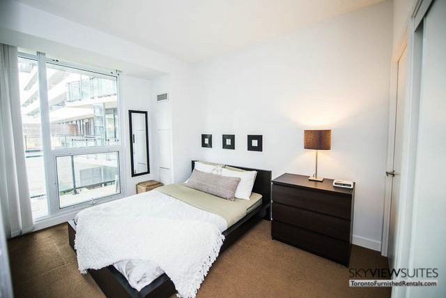 8 Telegram Mews serviced apartments toronto bedroom with dresser and lamp