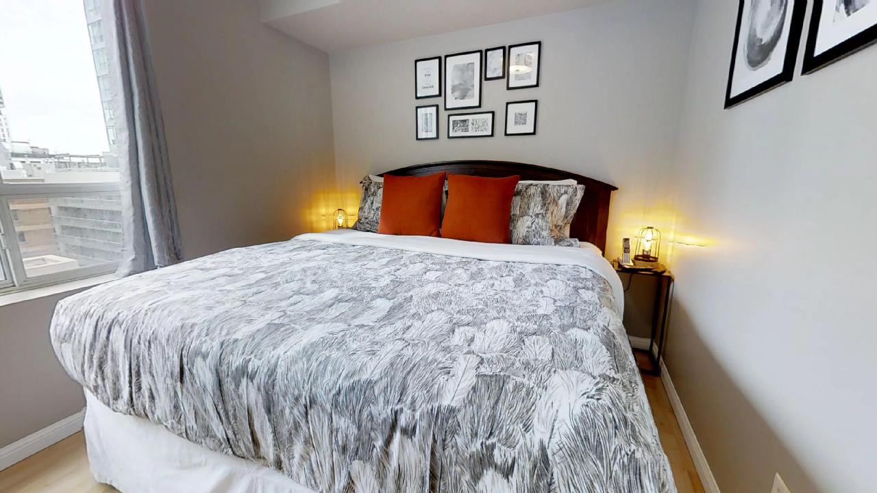 bedroom with red pillows at simcoe and richmond toronto funished apartment