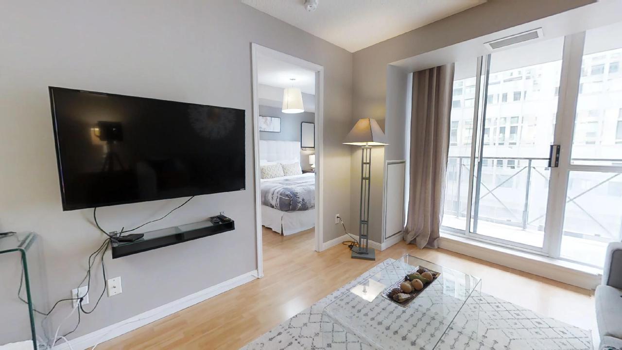 The television and bedroom in a toronto serviced apartment near Nota Bene restaurant