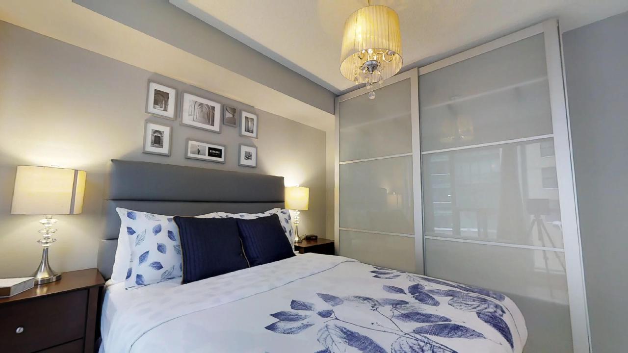 a blue bed and wall art in a furnished apartment, downtown toronto