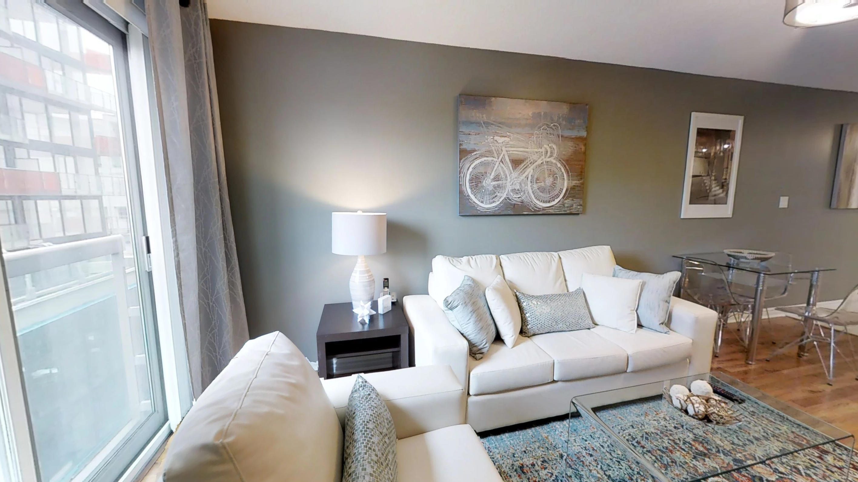 couch and side table in the living area of the Qwest building's furnished apartment, completed by Sky View Suites.